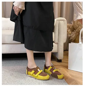 Dettaglio di una scarpa Mary Jane in pelle scamosciata marrone e gialla con velcro