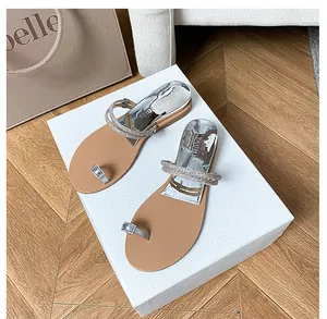 Detail of silver rhinestone toe loop sandals with sparkling straps and comfortable flat sole