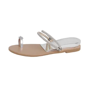 Women's flat thong sandals with sparkling rhinestone straps and silver mirror heel detail