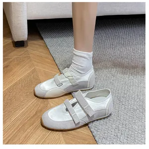 Dettaglio di ballerine Mary Jane grigie con doppio velcro su pavimento in legno