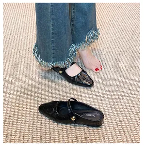 Detail of black Mary Jane mule with pleated square toe and gold buckle accent