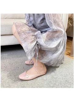 Elegante blassrosa Ballerinas mit Schleife und schmalen Riemen in Lifestyle-Umgebung