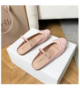 Detail von rosa Ballerinas mit eckiger Zehenpartie, kleiner Schleife und Riemchen