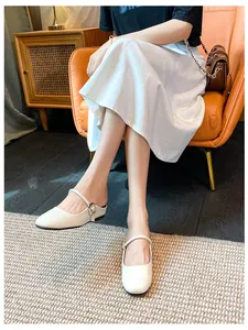 Close-up of stylish white Mary Jane mules with silver buckle and low heel on model