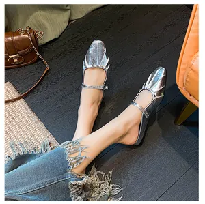 Close-up of stylish silver pleated square toe Mary Jane mules worn with blue jeans