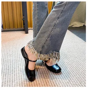 Close-up of black patent Mary Jane mules with buckled strap and 35mm platform sole