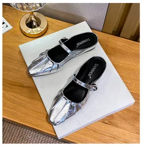 Close-up of silver metallic pleated Mary Jane mules with square toe and buckle detail