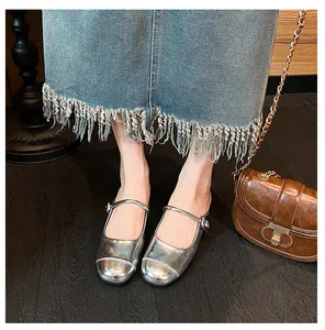 Detail shot of silver metallic Mary Jane shoes with buckle strap and round toe