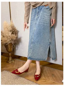 Gros plan sur des ballerines pointues avec boucles dorées et jupe midi en jean bleu