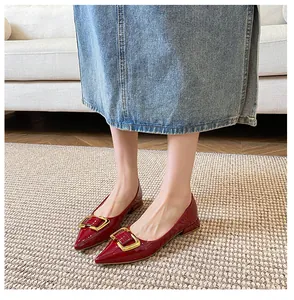 Détail de ballerines pointues en cuir verni rouge avec boucle carrée dorée chic