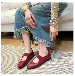 Close-up of red leather ballet flats with elastic strap and classic round toe design