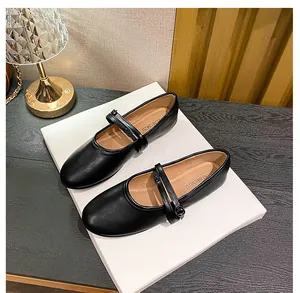 Close-up of matte black leather Mary Jane flat shoes with adjustable thin buckle strap