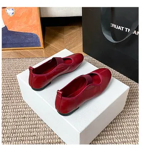 Detail of dark red leather Mary Jane flat shoes with elastic strap on marble display box