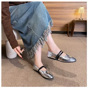 Close-up of silver metallic Mary Jane flats with dual black straps and round toe design