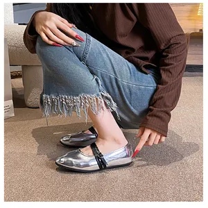 On-foot side view of silver metallic Mary Jane flats with slim black buckled straps