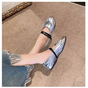 Detailed top-down shot of silver mirror Mary Jane flat shoes with black buckle straps