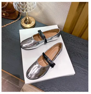Top view of silver Mary Jane flats with double black straps and metallic buckles on display