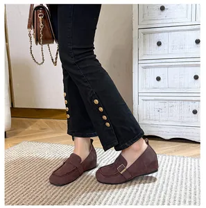 Detail view of dark brown suede loafers with a 5cm platform and metal buckle on the foot
