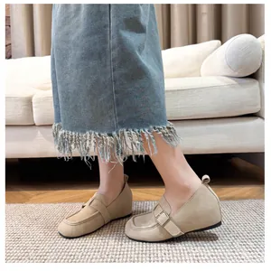 Detail of beige suede square toe loafers with 5cm platform and metal buckle strap on a model