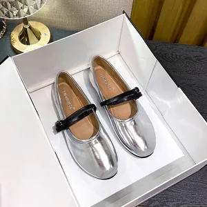 Silver metallic Mary Jane flats with black double straps in a white boutique box