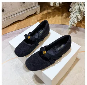 Détail des babies noires en peluche avec une boucle délicate en forme de rose dorée