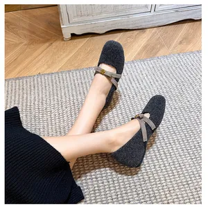 Détail de chaussures Mary Jane en polaire gris foncé avec brides croisées et bouton doré