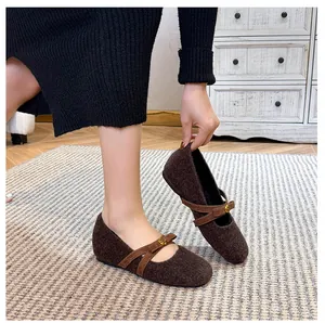 Détail de ballerines Mary Jane en laine marron avec boucle rose en métal et texture hiver