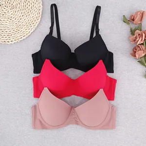 Three-pack ribbed lace-free bras in black, red, and pink on a textured background