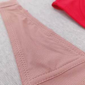Macro detail of breathable pink mesh fabric and reinforced stitching on lingerie wings