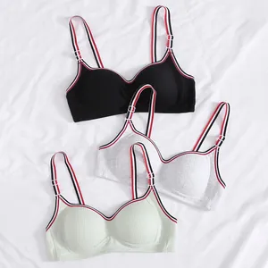 Detailed close-up of ribbed sports bras in three colors with striped elastic trim detail