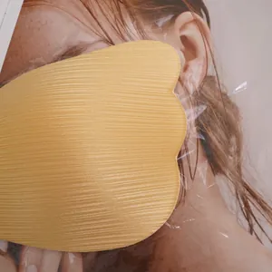 Close-up of yellow mango-shaped adhesive invisible bra with wave-cut fabric texture