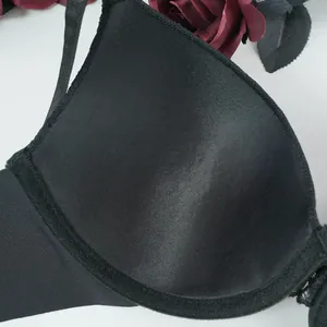 Close-up of black silk-textured bra with elegant lace detailing and red rose