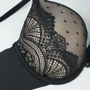 Close-up of black push-up bra featuring delicate floral lace and polka dot mesh textures
