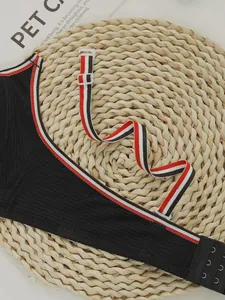 Close-up of black ribbed bra with tri-color striped straps and adjustable hooks