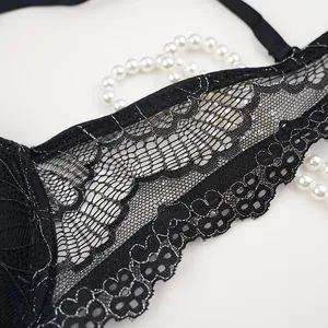 Macro detail of black lace lingerie with floral patterns and shimmering metallic threads