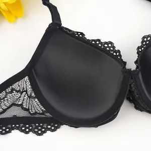 Macro detail of black lace embroidery and satin fabric texture on wired bra cup