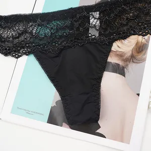 Detailed view of black lace thong with intricate scallop edges and premium silky fabric