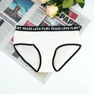 Detailed view of white ribbed cotton panties with black elastic PEACE LOVE band