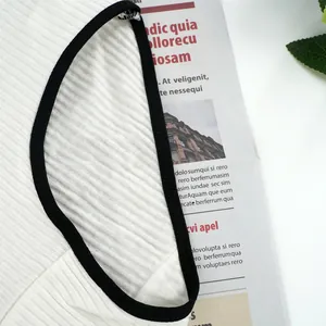 Detail shot of white ribbed fabric with premium black seam piping on the neckline