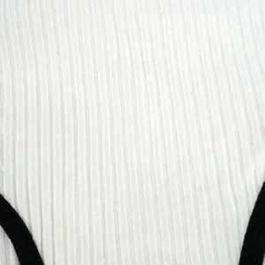 Detailed macro view of white ribbed knit fabric with contrasting black trim accents
