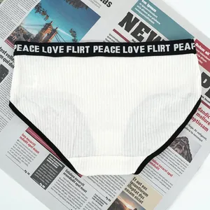 Close-up of white ribbed cotton panties with black peace love flirt elastic waistband