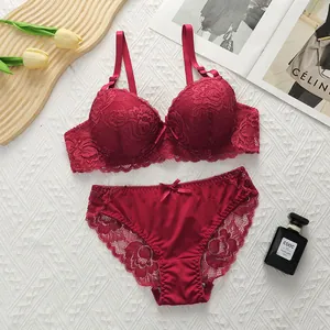 Detailed flat lay of burgundy lace lingerie set with silk satin details and floral texture