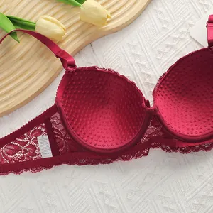 Detail of wine red lace bra featuring massage cup lining and delicate floral wings