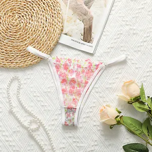 Detail of floral lace thong with pink flowers on white background with pearls