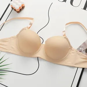Macro shot of seamless nude lace bra with smooth cups and adjustable thin straps