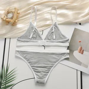 Detail van grijze en witte katoenen lingerieset zonder beugel in huiselijke sfeer