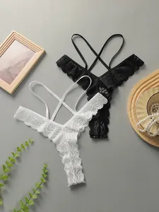 Vue à plat de strings en dentelle noirs et blancs avec brides croisées et fleurs