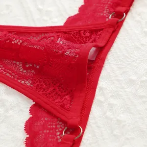 Detailed close-up of red floral lace fabric with a decorative silver metal ring buckle