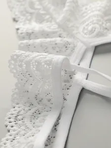 Gros plan sur la dentelle florale blanche montrant les textures et détails de couture