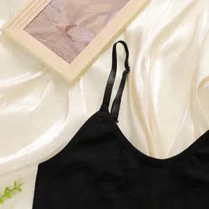 Detail of adjustable thin shoulder straps and V-neckline on a seamless black camisole top